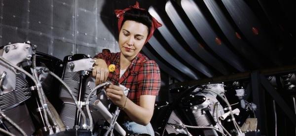 a WWII-era woman working on a motorcycle